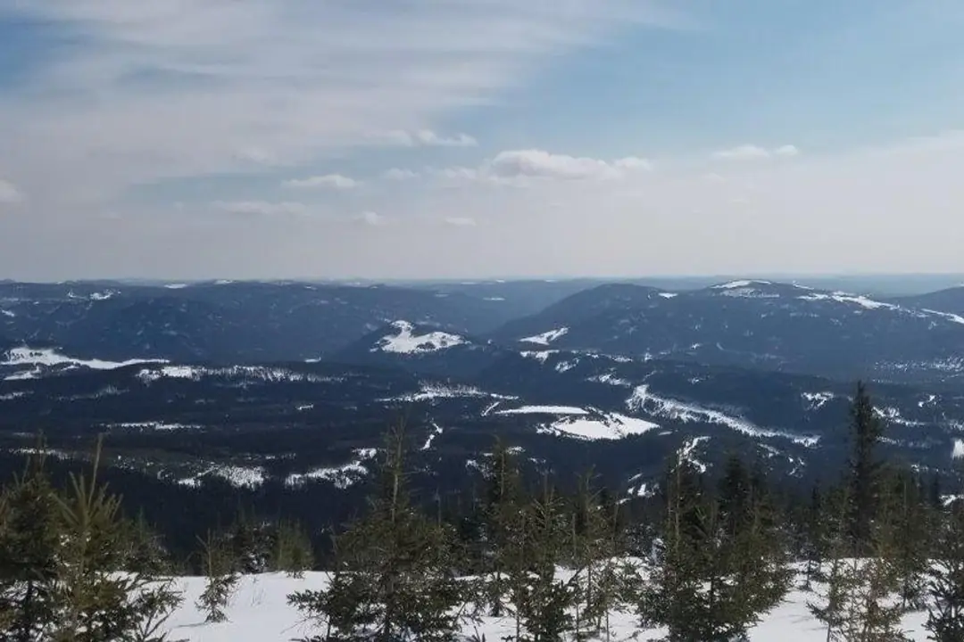 Vue panoramique sur une vallée de montagnes enneigées depuis un sommet